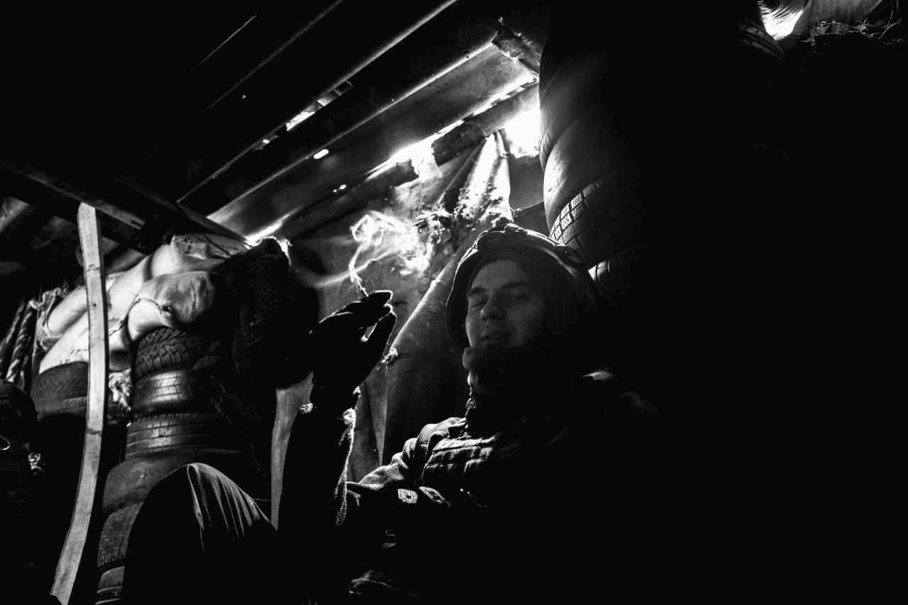 Доброволец подразделения «Борз» курит в окопах авдеевкой промзоны. Март 2023 г.