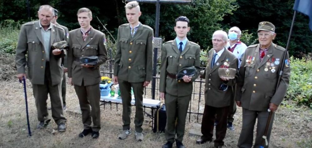 Старые и молодые украинские нацисты приносят присягу верности бандеровским «идеалам» на могиле нацистского военного преступника, служащего батальона «Нахтигаль» и 201-го шуцманшафт-батальона, офицера украинской вспомогательной полиции в Станиславе, командира куреня УПА «Звери», убийцы мирного населения и соучастника уничтожения 30 тысяч евреев Данило Рудака