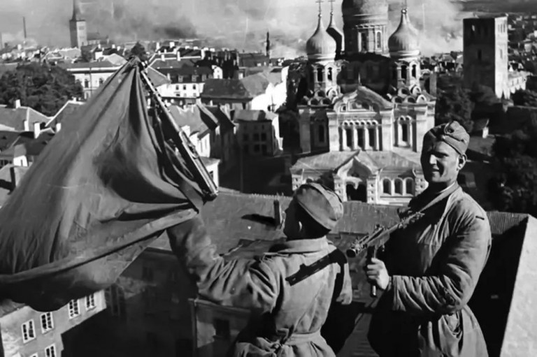 Бойцы Красной Армии поднимают красное знамя над старым городом Таллина. Военная фотография